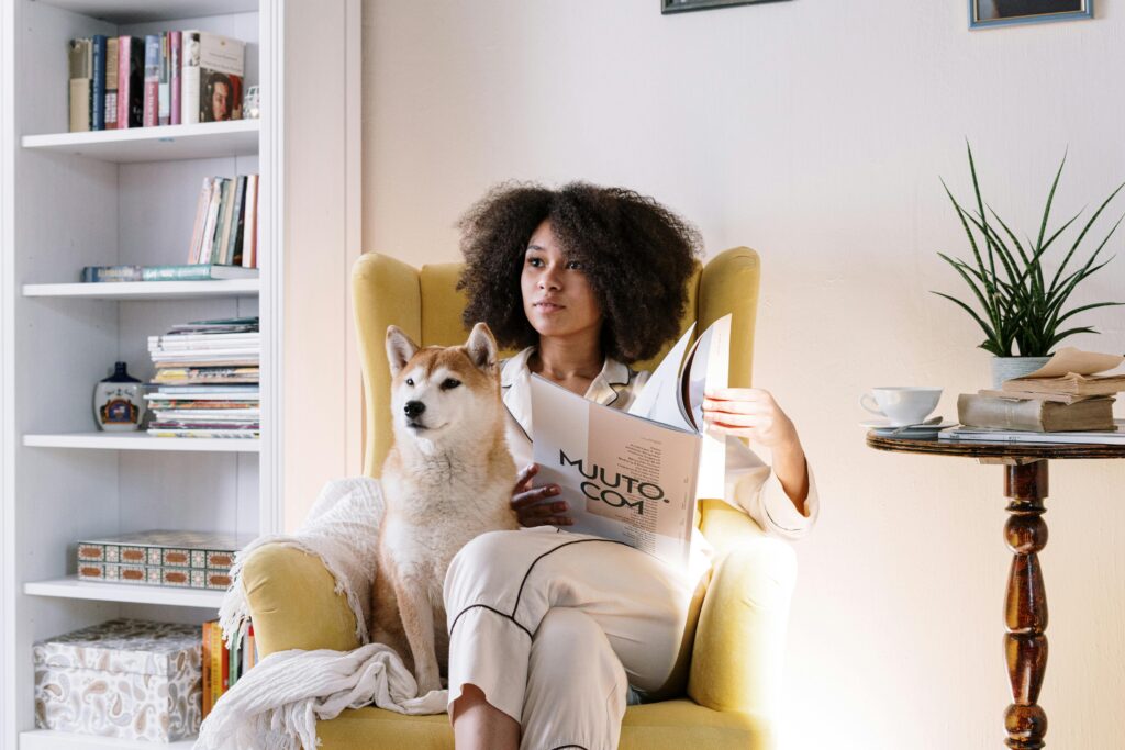 pexels-photo-4056475-4056475 Woman reading a magazine at home with her Shiba Inu dog on a cozy chair.